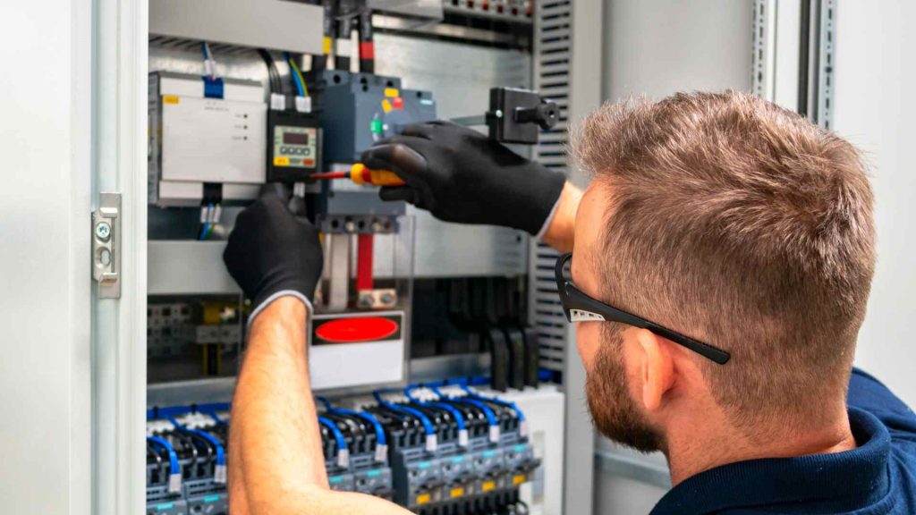 Licensed electrician working on an electrical panel during an emergency repair